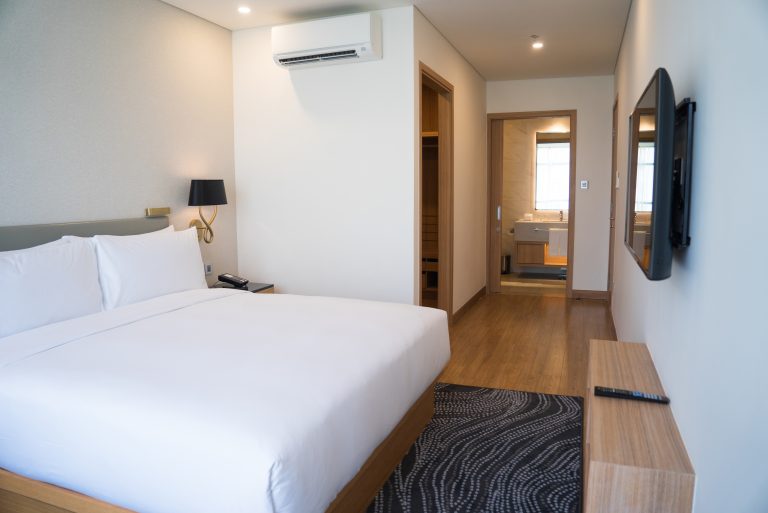 interior-pequeno-quarto-de-hotel-com-cama-de-casal-e-banheiro